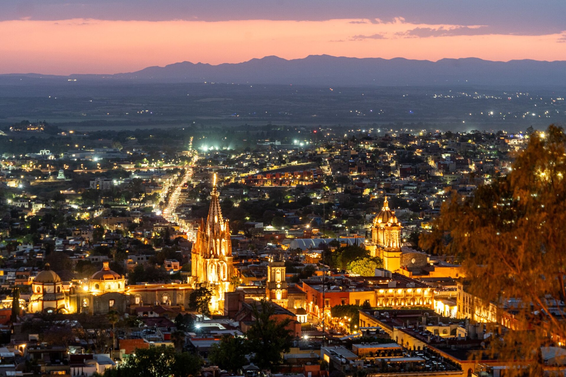The pink neo-Gothic spires of La Parroquia de San Miguel Arcangel glowing at twilight