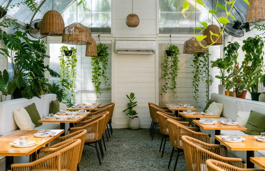 Plant-filled greenhouse dining room at Leche de Tigre Peruvian cebicheria near King William, San Antonio