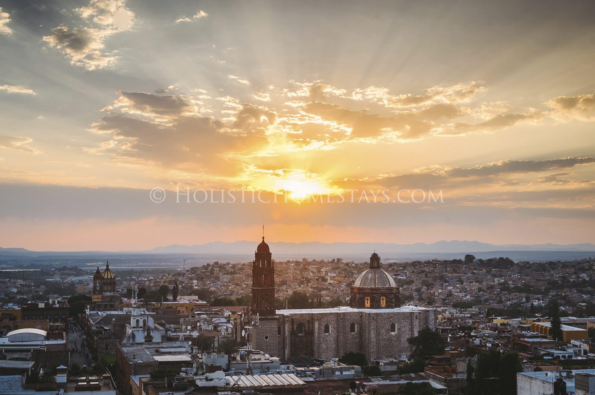 Golden sunset over the domes and rooftops of centro San Miguel de Allende from a rooftop terrace