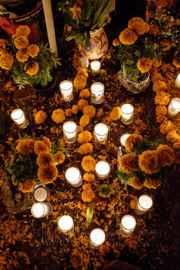 Candles and marigolds covering a grave during Noche de Muertos in the Lake Pátzcuaro region