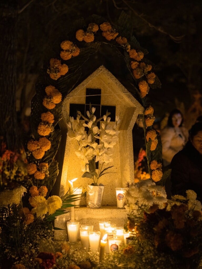 Day of the Dead altar framed by marigolds and glowing candles at night