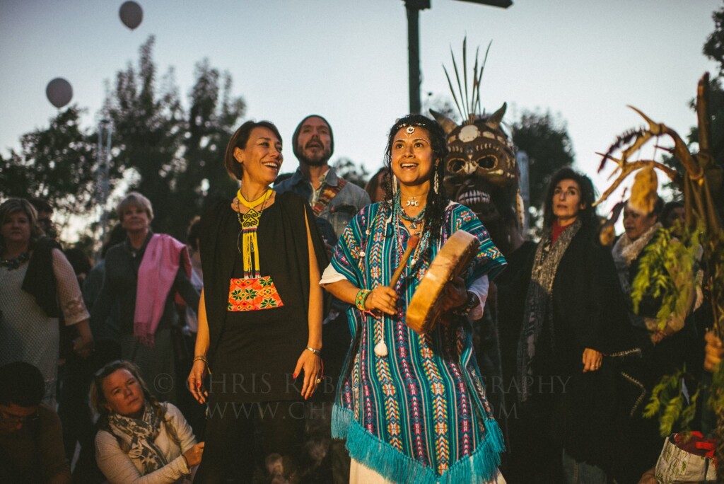 Women in traditional dress leading a joyful Día de Muertos street ceremony in San Miguel de Allende