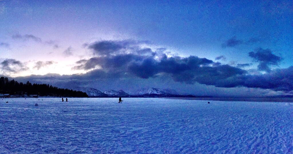 Snowy shoreline at dusk in South Lake Tahoe under blue clouds